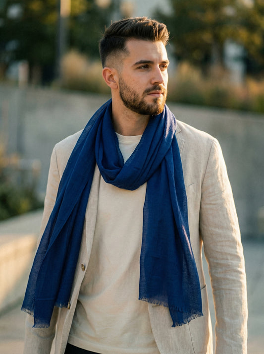 Man wearing indigo Moroccan Tagelmust as a breathable travel scarf, ideal for hot climate trekking and desert dust protection.